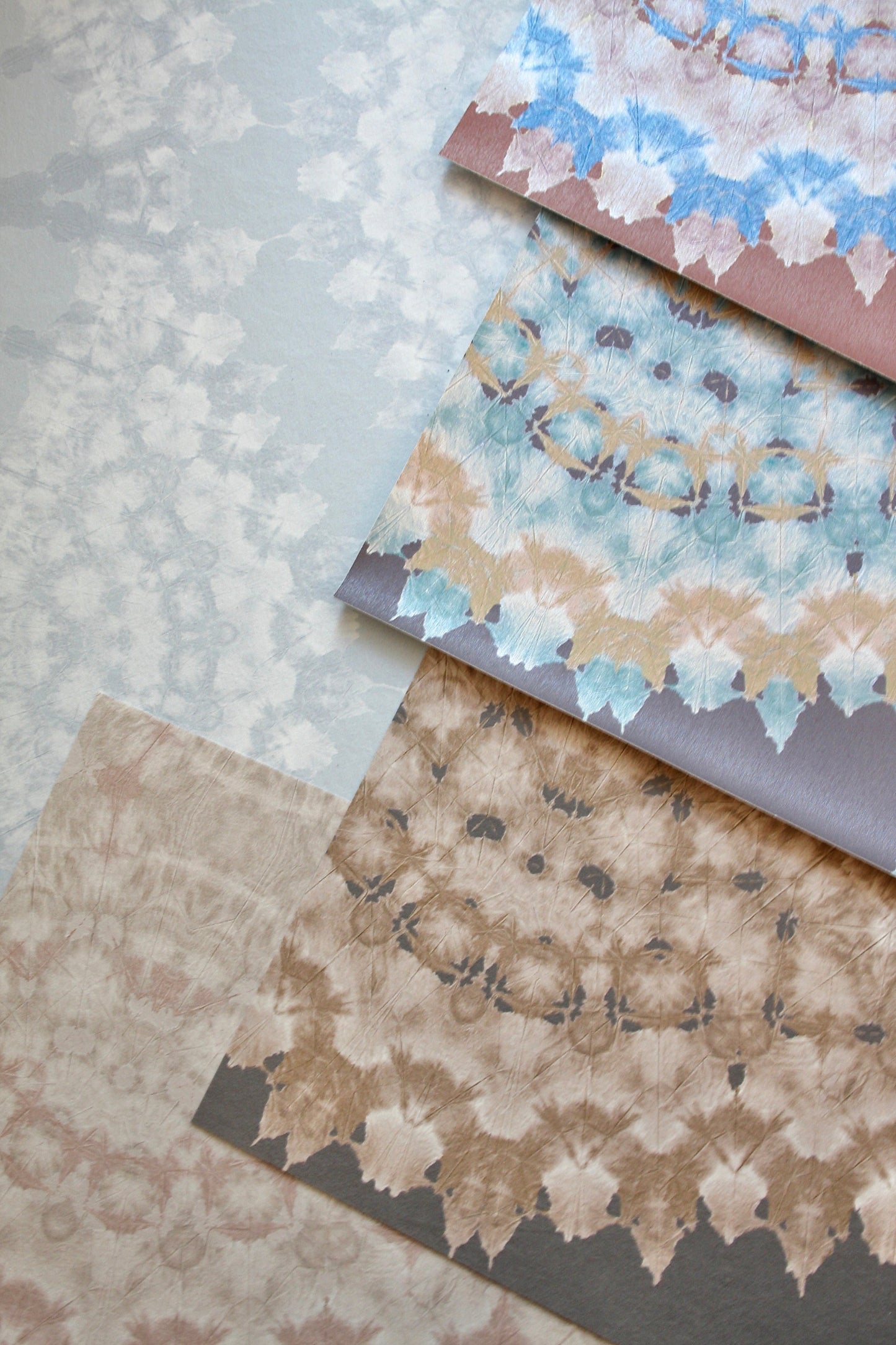 Collection of hand-dyed abstract lace on textured wall covering.