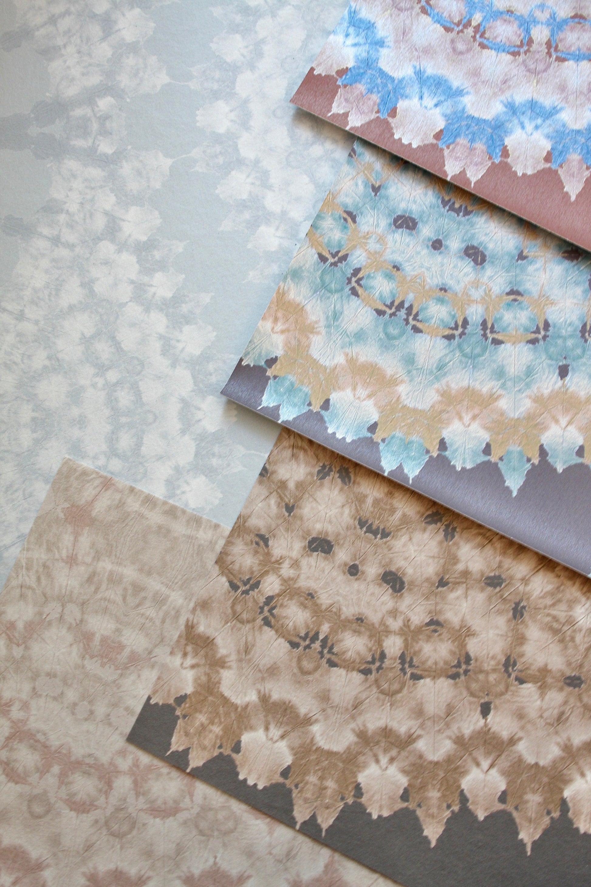 Collection of hand-dyed abstract lace on textured wall covering.