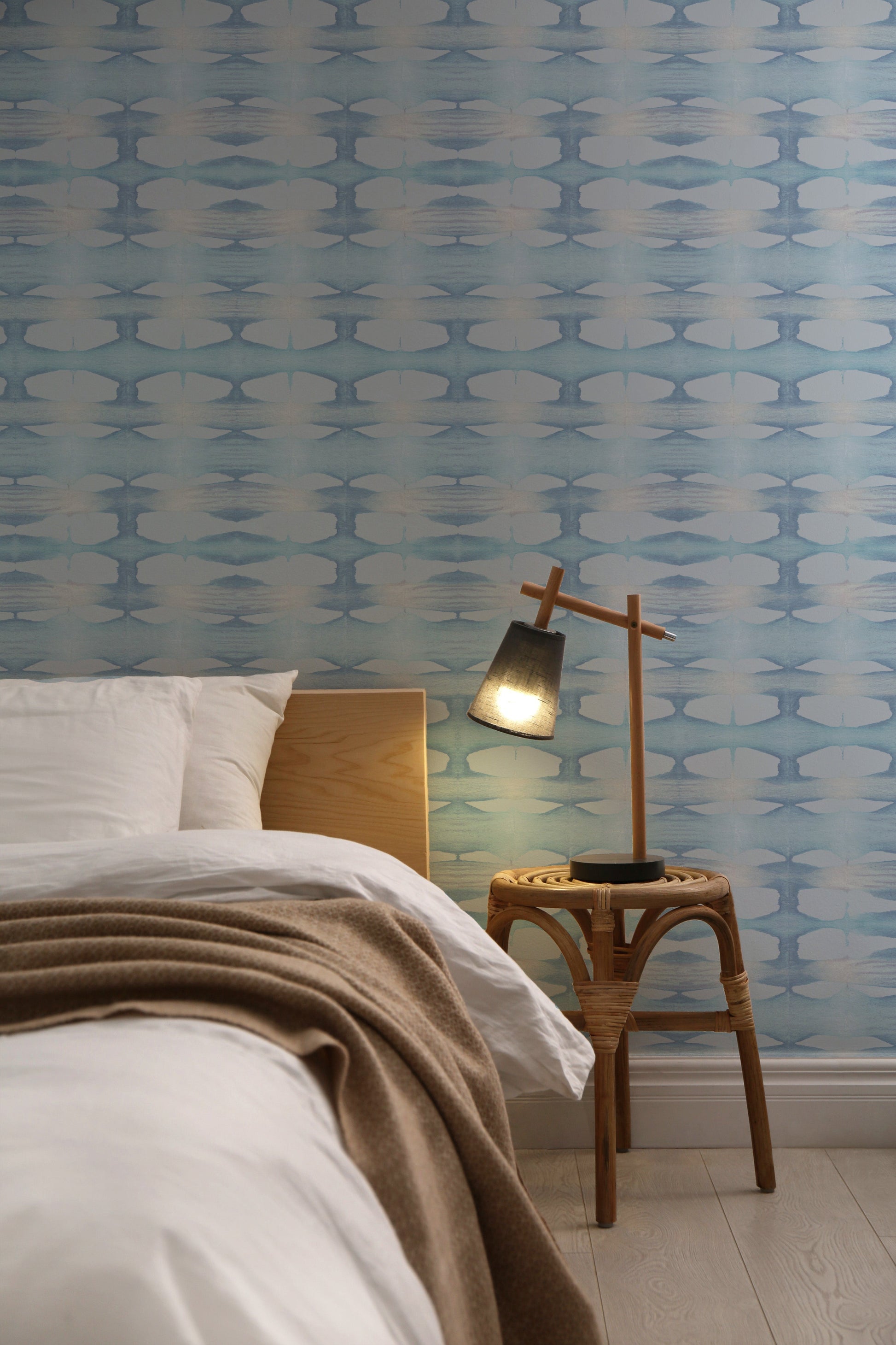 Bedroom with baby blue hand-dyed wallpaper.